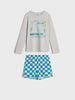 Children's pajama set with a long-sleeve shirt and checkered shorts on a white background