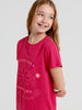 Young girl wearing a red t-shirt with a motivational design on a plain background