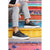 A person seated on colorful painted steps wearing black low-top sneakers with white soles and light gray sweatpants.