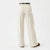 A pair of high-waisted, wide-leg trousers in cream or off-white, shown from the back on a model wearing a black belt and brown shoes against a plain white background.
