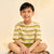 Child sitting cross-legged wearing a striped shirt and sandals on a plain background
