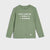 A sage green long-sleeve crewneck shirt for kids, featuring the white text 'WHEN I GROW UP I WANNA BE A DINOSAUR' across the chest and a small white dinosaur silhouette on the lower left hem.