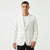 A man wearing a white shawl-collar blazer over a white t-shirt and black trousers, standing against a plain white studio background.
