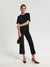 Woman wearing a black outfit with a handbag on a white background