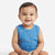 A smiling baby wearing a sleeveless blue tank top with a small sailboat pattern, sitting against a plain white background.