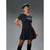 A woman modeling a short-sleeve plaid mini dress in dark navy and black, styled with a matching beret and black knee-high socks against a dark gray studio background.