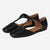 A pair of black leather flat shoes with square toes and T-strap designs, displayed on a clean white background.