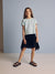 Young girl wearing a light green t-shirt and black skirt against a plain background with a cashback 20% offer.