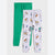 Two pairs of children's jogger sweatpants laid flat on a light gray background. The back pair is solid bright green, and the front pair is light heather gray with an allover colorful graphic print featuring cartoon vehicles and text.