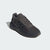 Black Adidas sneaker on a light gray background