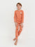 Child wearing a matching orange pajama set with a white background
