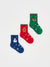 Three Christmas-themed socks in red, green, and blue on a white background