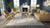 Modern living room with beige sofa, chairs, and a fireplace.