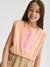 Young girl wearing a peach sleeveless top with colorful text on a white background