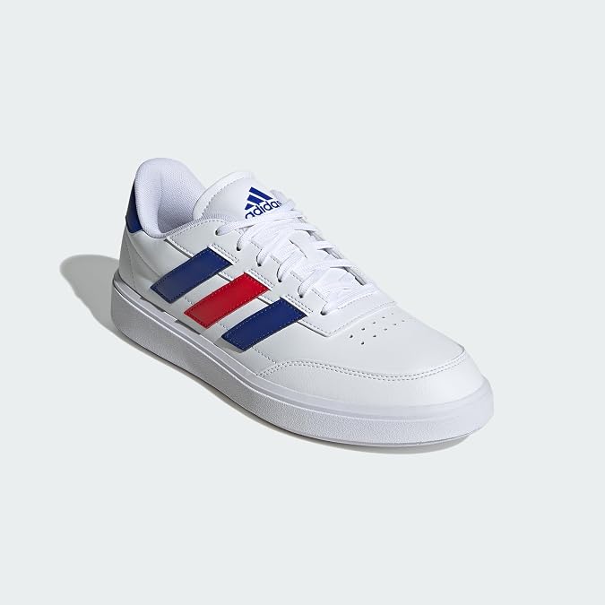 White Adidas sneaker with blue and red stripes on a light gray background