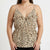 A woman wearing a beige camisole top with a black leopard print pattern, ruffled straps, and a gathered waist, shown against a plain white background.