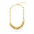 A gold crescent moon necklace with a paperclip chain, featuring small clear and blue gemstones set into the curve, shown on a plain white background.