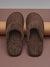 Pair of brown slippers on a beige background