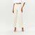 A model wearing off-white wide-leg cropped pants with a raw hem, styled with a white tie-front crop top and white strappy high-heeled sandals against a plain white studio background.