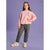 A young girl modeling a light pink crewneck sweatshirt with a front pocket holding white pens, paired with dark gray jogger pants and white sneakers, set against a solid lavender studio background.