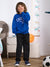 A child wearing a bright blue sweatshirt with 'CHICAGO' printed in white on the front, paired with dark pants and blue sneakers, standing in a child's bedroom.