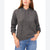 A woman wearing a dark gray heathered knit pullover hoodie with drawstrings and blue jeans, shown from the lips down against a plain white background.