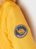 Yellow jacket with a 'Brave and Wild' dinosaur patch on the sleeve.