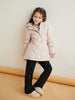 Young girl wearing a light pink jacket with a pattern, standing against a plain background.