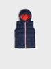 Navy blue puffer vest with red interior lining on a light gray background