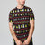 A man wearing a black short-sleeve t-shirt with a colorful 'Alien' themed holiday pattern, posed against a solid gray studio background.