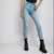 A model wearing light-wash blue skinny jeans with black platform ankle boots, shown from the waist down against a light gray studio background.