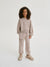 Child wearing a beige tracksuit on a white background