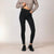 A model wearing high-waisted black skinny jeans with a button-fly front, styled with a cropped gray knit sweater and black leather shoes against a neutral studio backdrop.