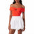 An off-the-shoulder two-piece outfit featuring a bright orange top with a large bow detail and a white high-waisted flared skirt, shown on a model against a white background.