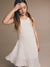 Young girl wearing a white dress against a beige background