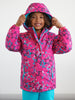 Child wearing a pink raincoat with star patterns on a white background
