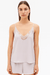 Woman wearing a light purple lace-trimmed camisole and shorts on a white background