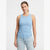 A woman modeling a light blue ribbed sleeveless tank top with light-wash jeans against a plain light gray studio background.