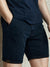 Person wearing navy blue shorts and a matching shirt against a neutral background
