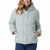 A woman wearing a light sage green hooded puffer jacket with a button-front closure and side pockets, paired with blue jeans, against a plain white background.