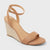 Tan wedge sandal with espadrille sole on a light gray background