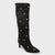 A black suede knee-high boot with a pointed toe and slim kitten heel, decorated with multiple gold-tone metal studs, shown against a light gray background.