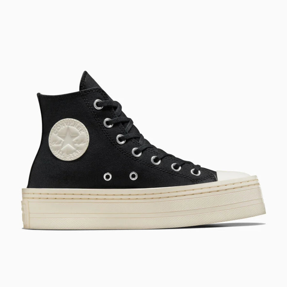A black high-top canvas sneaker with a chunky off-white platform sole, featuring a circular off-white Converse star patch on the side and silver eyelets, shown against a plain white background.