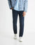 Person wearing navy pants, light blue shirt, and denim jacket on a white background