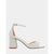 A single white embellished block-heel sandal with an ankle strap, decorated with rhinestones and pearls, shown from a side profile on a light gray background.