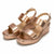 A pair of metallic rose gold platform wedge sandals with double front straps and adjustable ankle straps, shown on a clean white background.