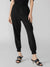 Person wearing black high-waisted pants on a light gray background