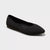 Black flat shoe on a light gray background