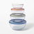 Set of glass mixing bowls with colored lids on a white background