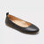Black flat shoe on a light gray background